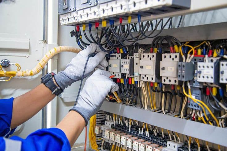 Técnico ajustando disjuntores em painel elétrico